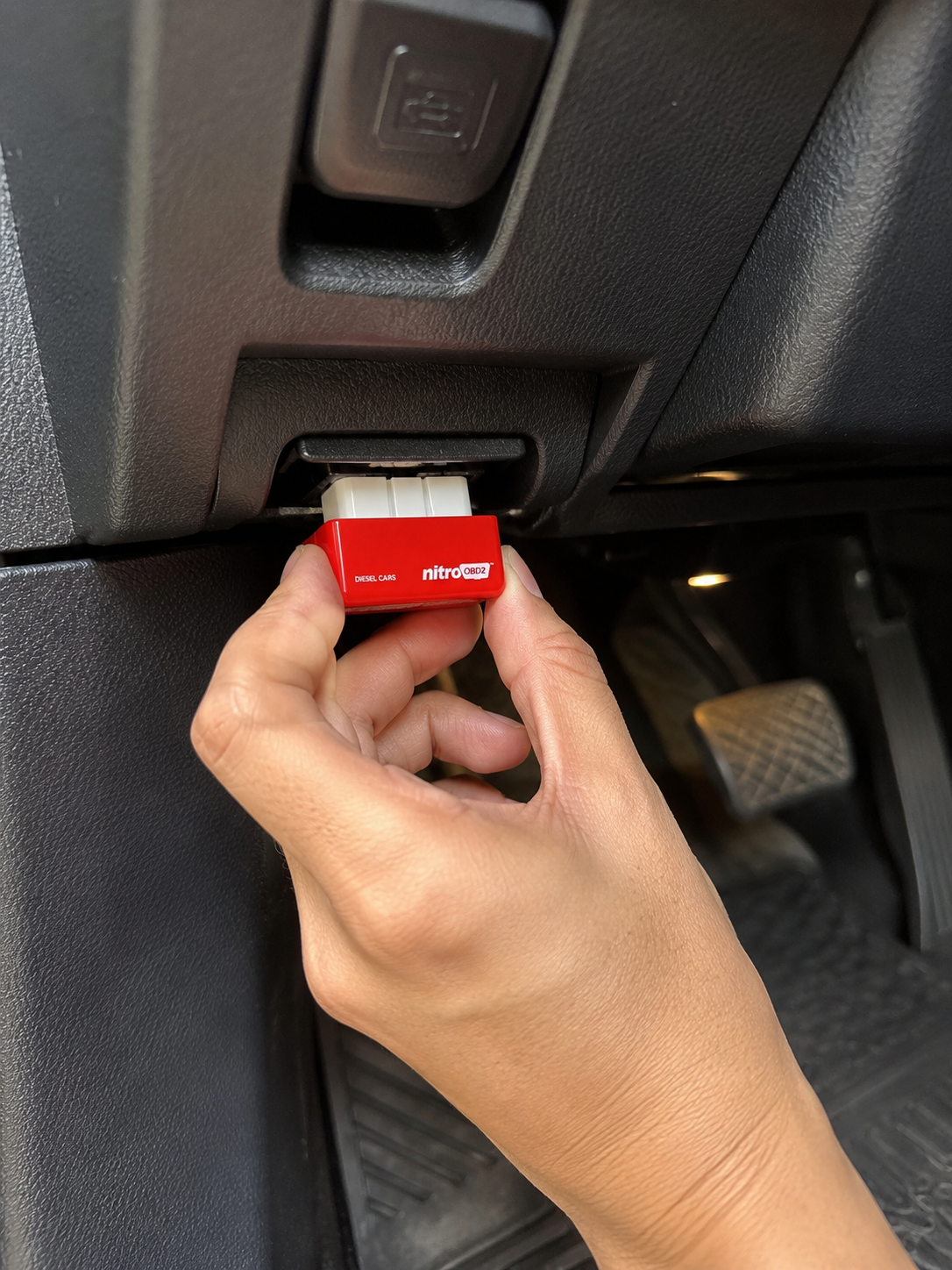 Nitro OBD2 chip being plugged into a diesel vehicle's OBD2 port